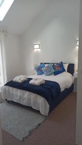 ein Schlafzimmer mit einem großen Bett mit blauen Kissen in der Unterkunft Petite propriété de prestige entre Paris et Disneyland in Le Plessis-Trévise