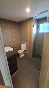 y baño con aseo, lavabo y ducha. en Aeropod KK Corner Unit Near City and Airport 4 pax Free Parking, en Kota Kinabalu