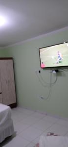 a room with a tv with a video game on the wall at Flats Xingó in Piranhas