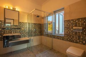 a bathroom with a glass shower and a sink at StayVista at Albert Estate in Mussoorie +120 photos