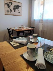 une table en bois avec des assiettes et des tasses au-dessus dans l'établissement RIBA D'AUDE, à Carcassonne