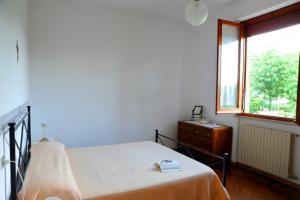 1 dormitorio con cama, ventana y vestidor en Agriturismo La Pietriccia, en Chianciano Terme