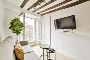 a living room with a couch and a tv at New&renovated cosy flat in The marais !!! 4pers in Paris