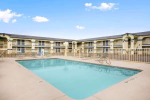 a swimming pool in front of a building at Travelodge by Wyndham Killeen/Fort Hood in Killeen