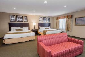 a hotel room with two beds and a couch at Baymont by Wyndham Lancaster in Lancaster