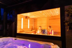 two women standing in a bath tub in a mirror at Arena Deluxe & Spa in Szeged