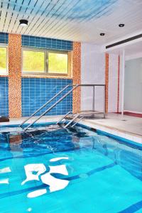 an indoor swimming pool with blue water at Hotel Ostermann in Treis-Karden