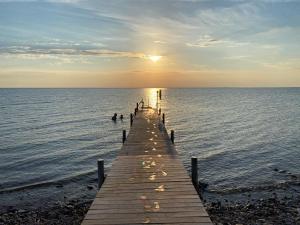 a pier stretches out into the ocean at sunset at Äleklinta Gård in Äleklinta