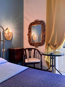 a bedroom with a bed and a mirror and a chair at Amaranta in Palermo