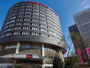 Un grand bâtiment avec un panneau en haut dans l'établissement Mercure Paris La Défense, à Courbevoie