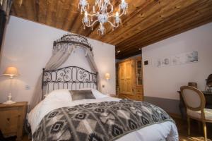 a bedroom with a large bed and a chandelier at Paccard Locations Chamonix in Chamonix-Mont-Blanc