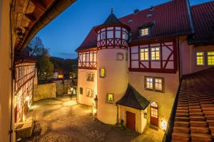 a large building with a tower in a town at night at Burg Bodenstein in Adelsborn