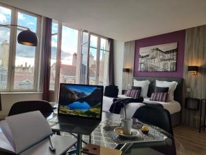 a hotel room with a bed and a desk with a laptop at City Loft Apparthotel in Dijon