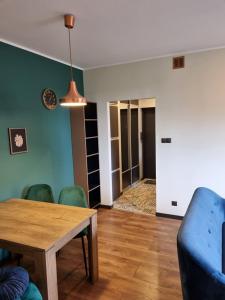a living room with a table and green chairs at JBHotels Apartament Premium in Szczecin