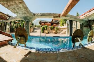 BoljevacHotel Etno Centar Balasevic的房屋旁带椅子的游泳池