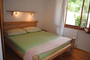 1 dormitorio con 1 cama con cabecero de madera y ventana en Apartments Natura Makarska, en Makarska