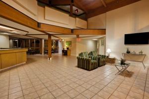 a lobby with two chairs and a flat screen tv at La Quinta by Wyndham St. Pete-Clearwater Airport in Clearwater