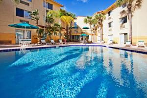 una piscina in un hotel con sedie e ombrelloni di La Quinta by Wyndham St. Pete-Clearwater Airport a Clearwater