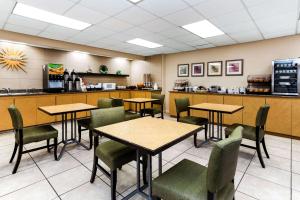 a restaurant with tables and chairs and a counter at La Quinta by Wyndham St. Pete-Clearwater Airport in Clearwater