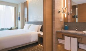 
a hotel room with a bed and a mirror at JEN Singapore Orchardgateway by Shangri-La - SG Clean in Singapore
