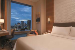a hotel room with a bed and a large window at JEN Singapore Orchardgateway by Shangri-La in Singapore