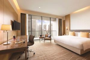 a hotel room with a large bed and a desk at JEN Singapore Orchardgateway by Shangri-La in Singapore