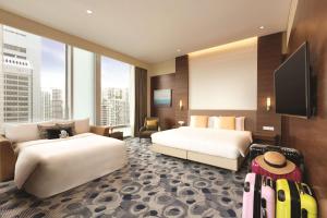 a hotel room with two beds and a flat screen tv at JEN Singapore Orchardgateway by Shangri-La in Singapore