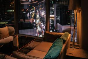 a living room with a couch and a large window at JEN Singapore Orchardgateway by Shangri-La in Singapore