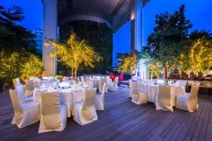 a set up for a wedding with white tables and chairs at JEN Singapore Orchardgateway by Shangri-La in Singapore