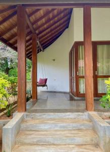 a porch of a house with a swing at Sanjis The Seaside Cabanas in Tangalle