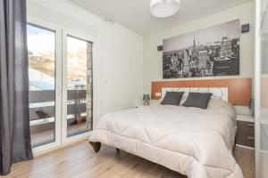 a white bedroom with a large bed and a window at Apartamentos Vaquers MIKKA 3000 in Pas de la Casa