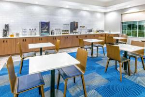 una caffetteria con tavoli, sedie e bancone di La Quinta by Wyndham Jacksonville, Texas a Jacksonville