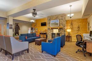 Comfort Suites Anchorage International Airport في أنكوراج: غرفة معيشة مع كراسي زرقاء ومدفأة