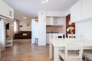a kitchen and living room with a white table and chairs at Apartamentos Vaquers MIKKA 3000 in Pas de la Casa