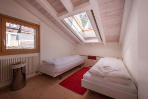ヴェンゲンにあるChalet Schneehoren Penthouseのベッドが2つと窓がある小さな部屋