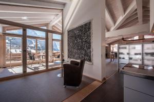 a living room with a chair and a table at Chalet Schneehoren Penthouse in Wengen
