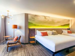 a hotel room with two beds and a painting on the wall at Novotel Itu Terras de São José Golf & Resort in Itu