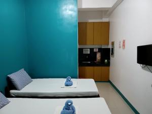 a small room with two beds and a tv at Pete's inn in Roxas City