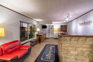 a lobby with a red couch and a bar at Travelodge by Wyndham Pigeon Forge in Pigeon Forge