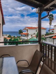 a balcony with a table and chairs and the ocean at Liogerma Apartments in Pefkochori