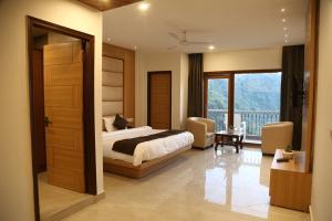 a bedroom with a bed and a large window at Shining Hills in Mussoorie