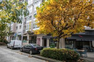 una calle con coches estacionados frente a un edificio en Hotel PAYRO ** en Santiago de Compostela