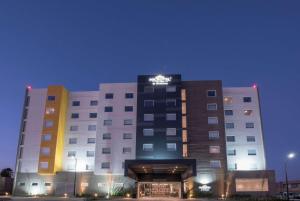 グアダラハラにあるMicrotel Inn & Suites by Wyndham Guadalajara Surの上に看板があるホテルの建物