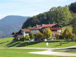 a large house on top of a green hill at Landhotel Maiergschwendt inkl Chiemgaukarte in Ruhpolding