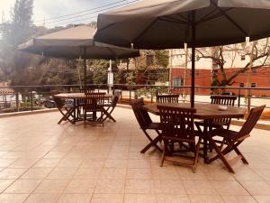 2 mesas y sillas con sombrillas en un patio en Nersheys 2 bedroom Apartment near Junction Mall, en Nairobi