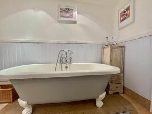 a white bath tub in a bathroom with a sink at The Writer's Cottage in Deal +12 photos