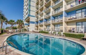a swimming pool in front of a building at Stunning Condo with Wall-to-Wall Windows Overlooking Ocean in Myrtle Beach