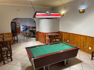 uma mesa de bilhar num quarto com pessoas num restaurante em Buffalo Hotel em Hectorspruit