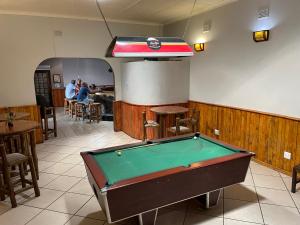 einen Billardtisch in einem Zimmer mit Leuten in einem Restaurant in der Unterkunft Buffalo Hotel in Hectorspruit