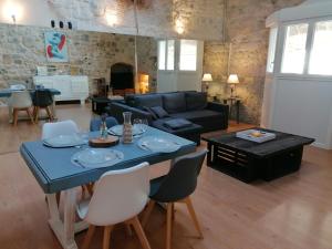 een woonkamer met een tafel en een bank bij LE LOFT in Casteljaloux